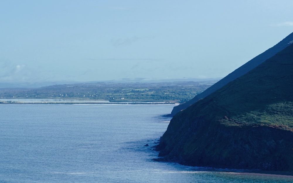 a large body of water with a mountain in the background