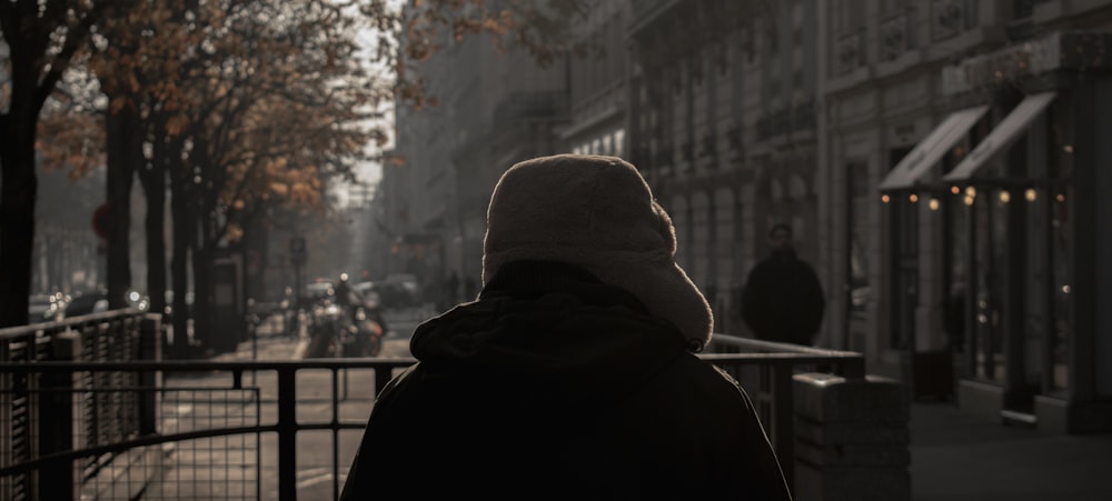 a person walking down a street next to tall buildings