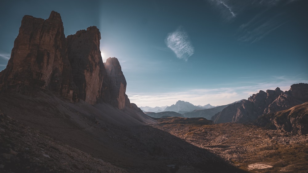 the sun shines on a rocky mountain range