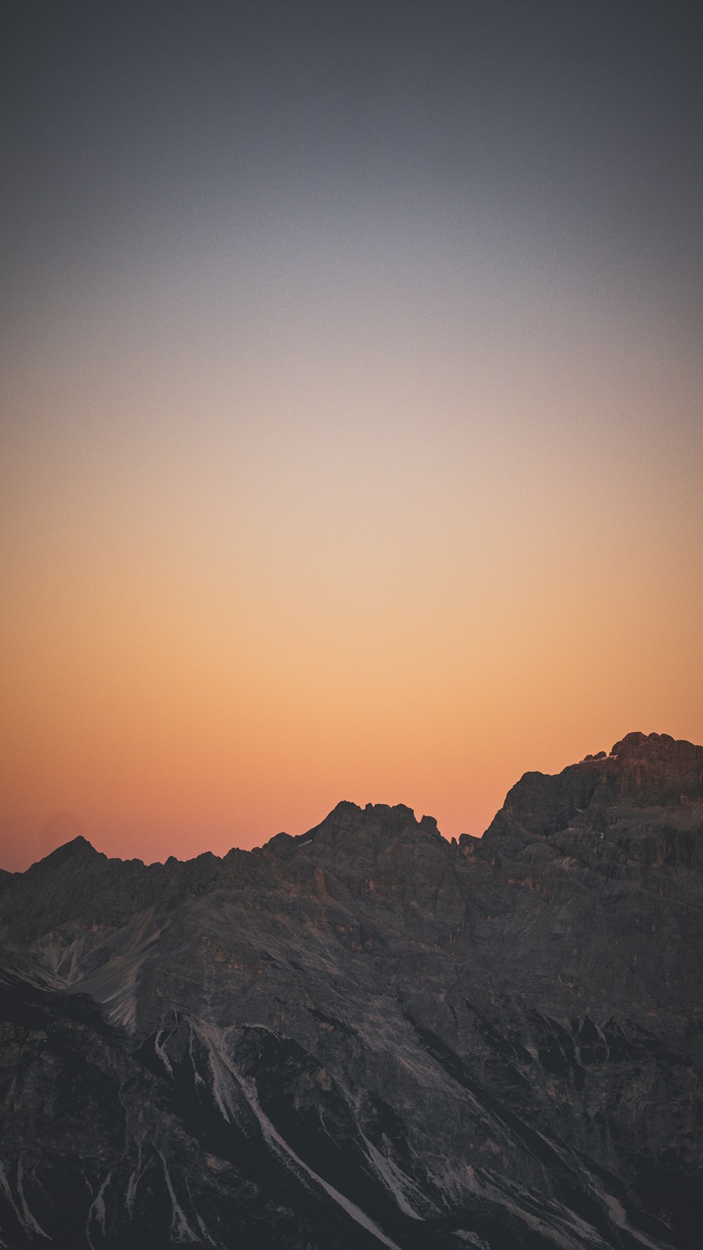 a plane flying over a mountain range at sunset