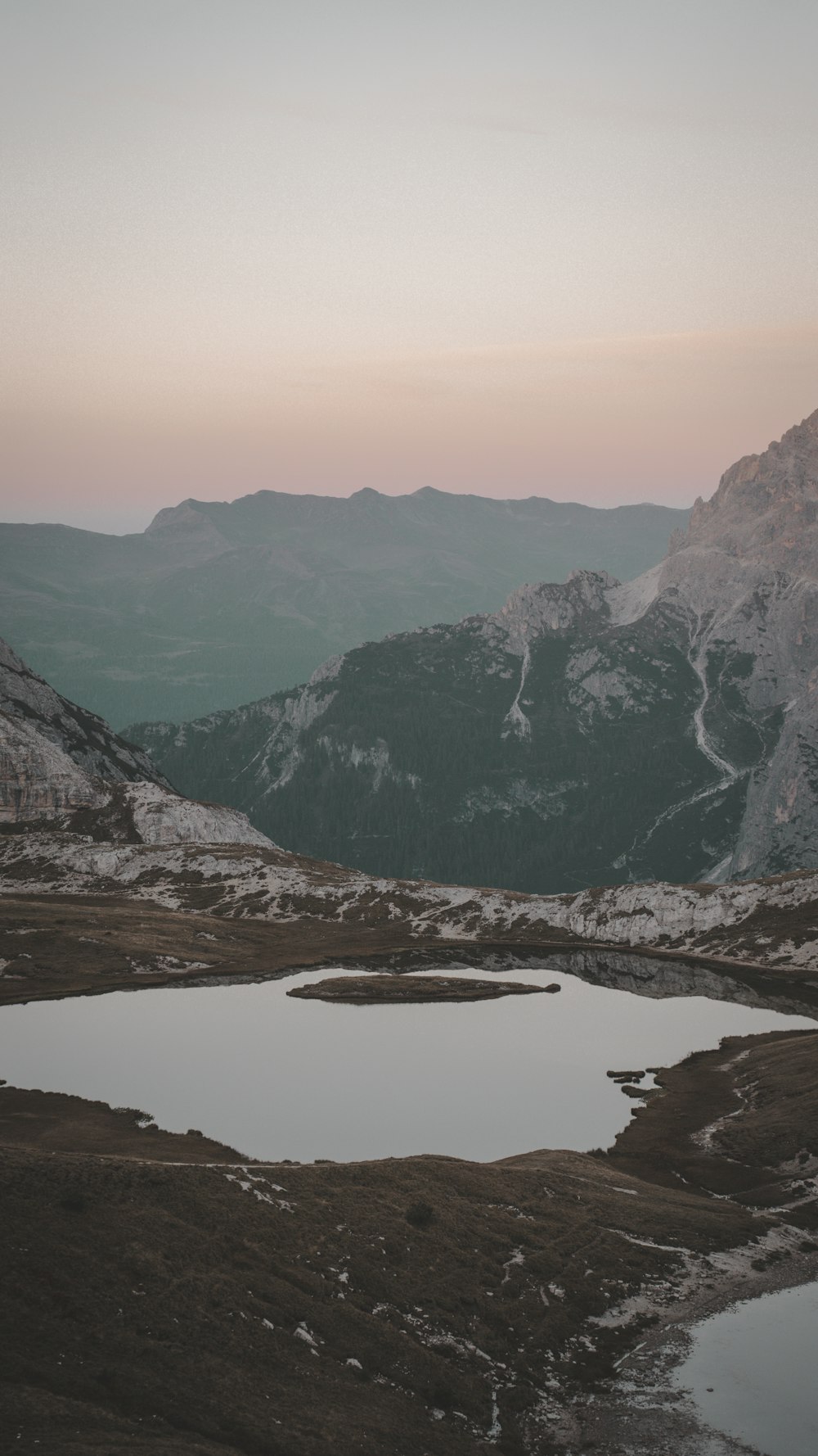 a mountain range with a lake in the foreground