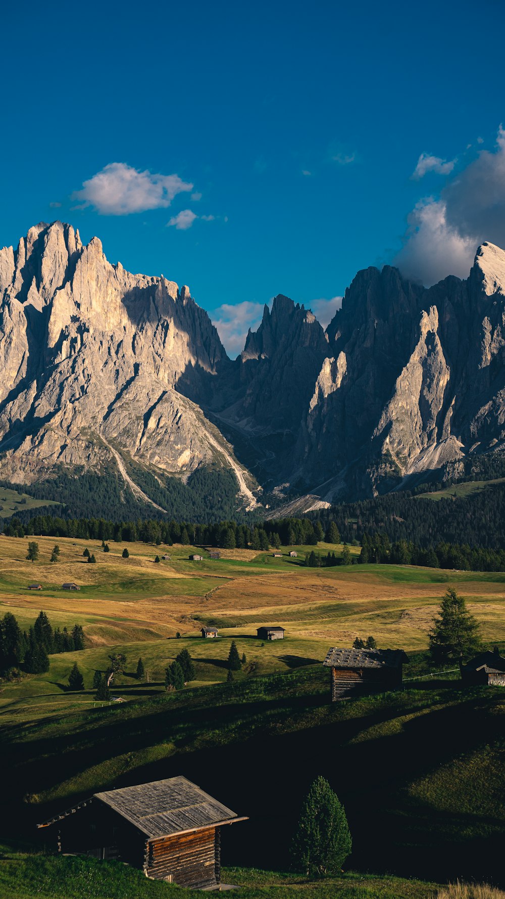 a mountain range with a small cabin in the foreground