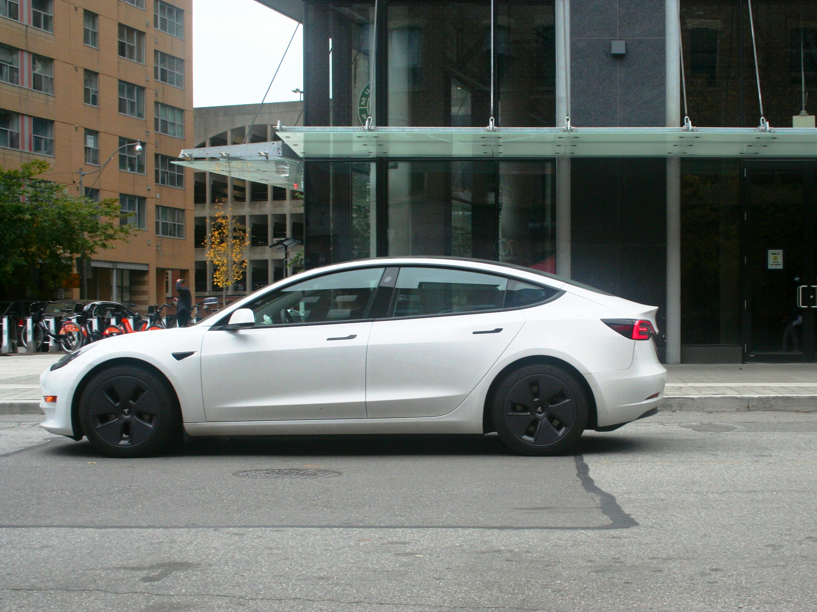 Tesla Model 3 driving on the road, highlighting the importance of brake maintenance