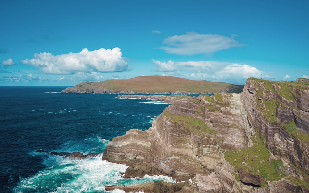 a rocky cliff overlooks a body of water