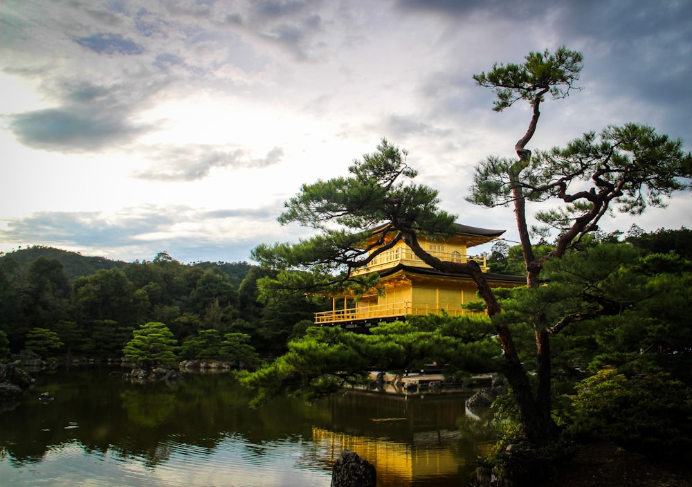 a yellow building sitting on top of a lush green hillside