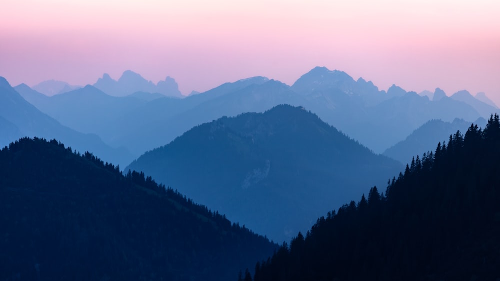 a view of a mountain range with trees in the foreground