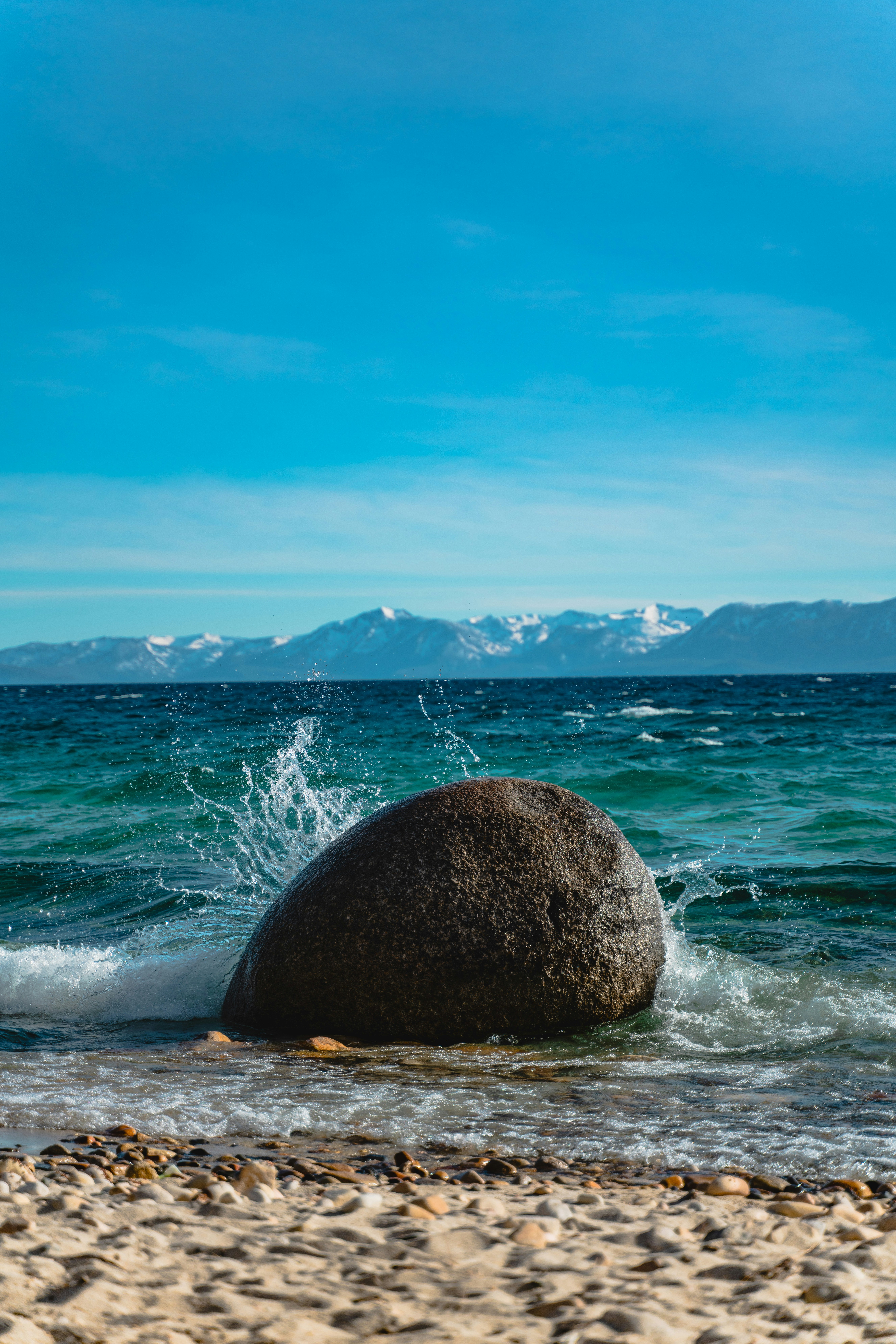 A large rock sitting on top of a sandy beach photo – Free Blue Image on ...