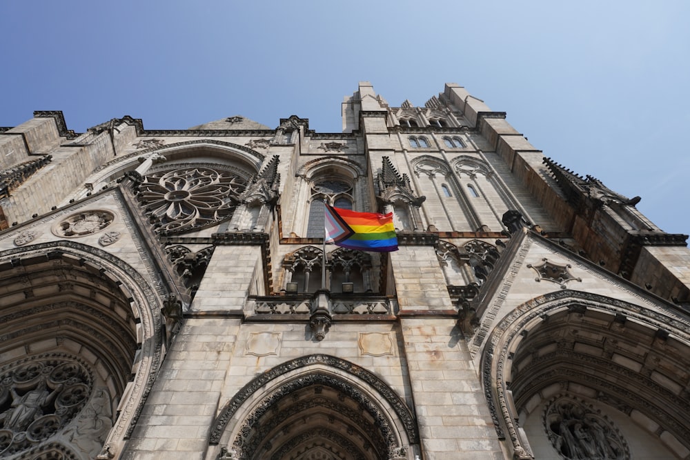 a rainbow flag is hanging on the side of a building