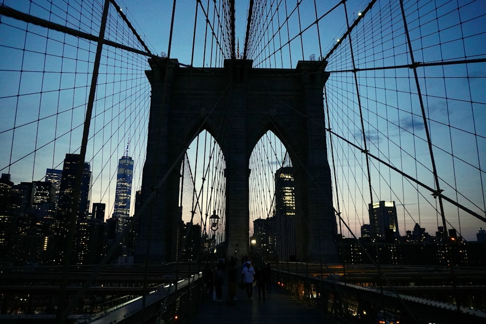 a group of people walking across a bridge