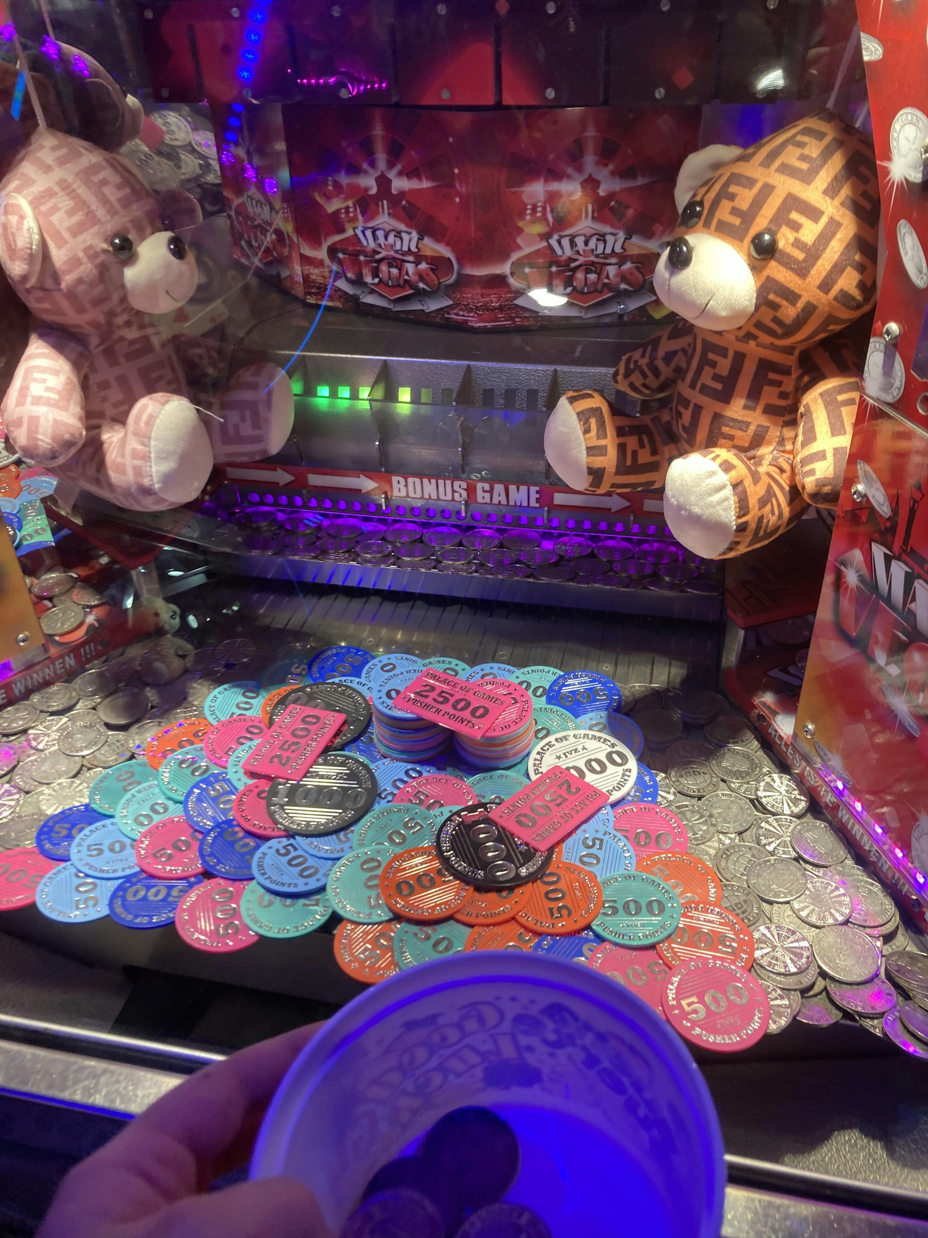 a person is holding a cup in front of a game machine