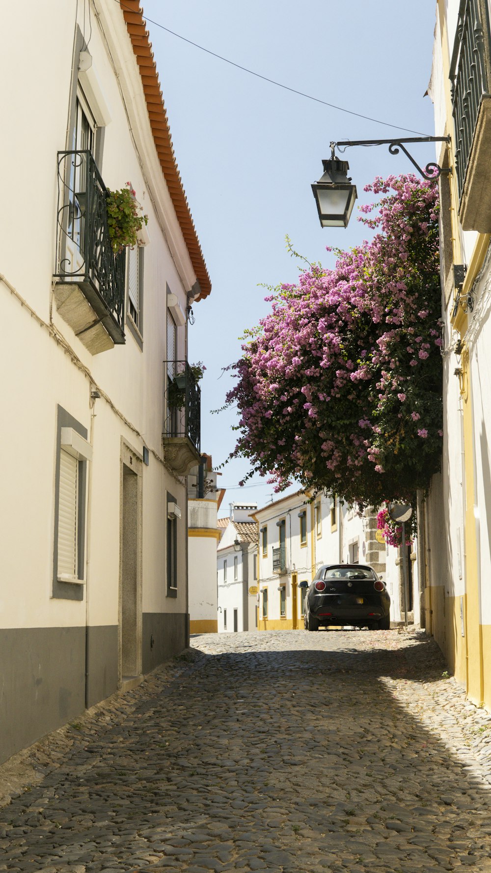 a car is parked on a cobblestone street