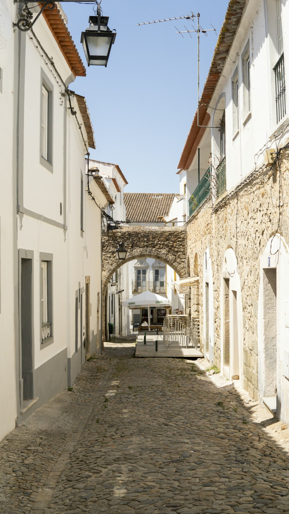 a cobblestone street lined with white buildings