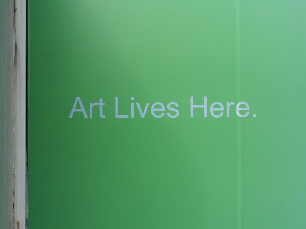 a green sign that says art lives here