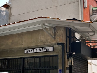 a sign on the side of a building that says make it happen