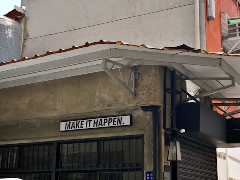 a sign on the side of a building that says make it happen