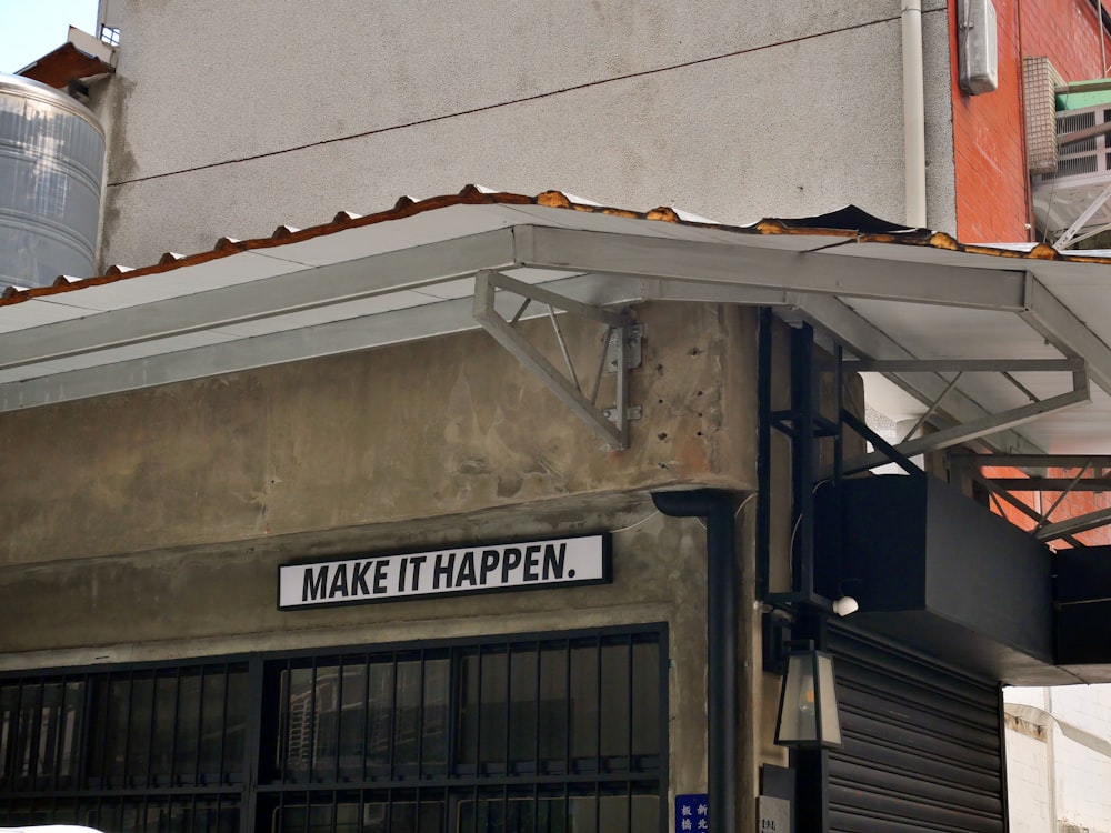 a sign on the side of a building that says make it happen