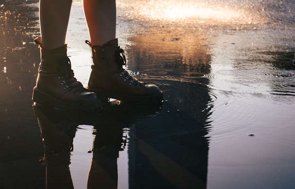 A sturdy pair of boots worn on a rocky trail at dawn.
