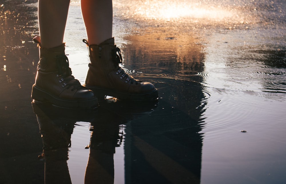 a person standing on a puddle with their feet in the water