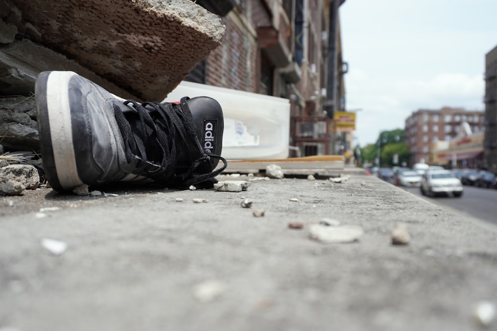 a pair of black shoes sitting on the side of a road