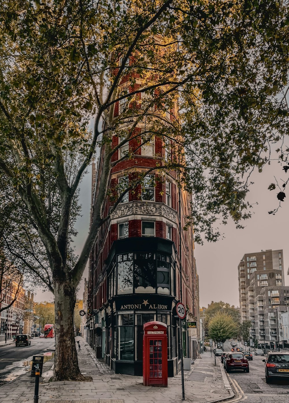a red phone booth sitting on the side of a street