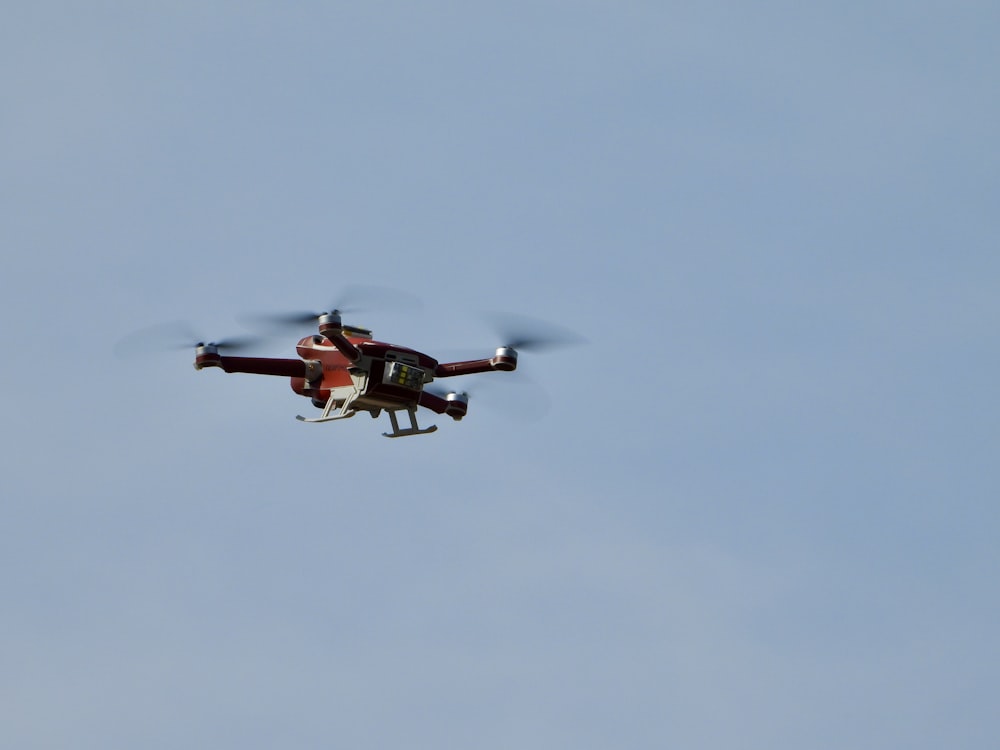 Ein rot-weißer Hubschrauber fliegt durch einen blauen Himmel