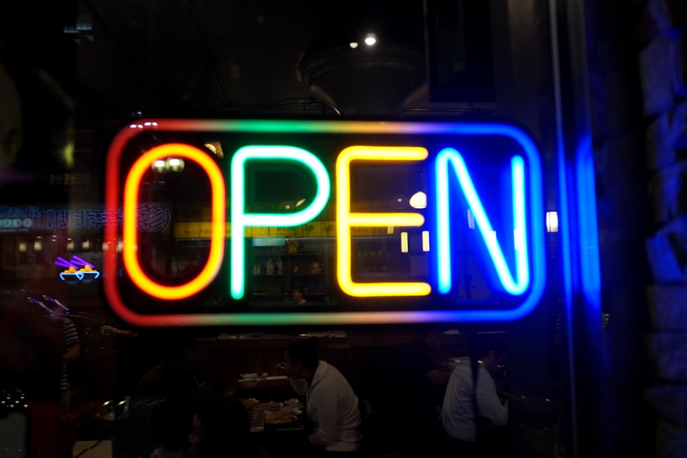 a neon sign that says open in a window