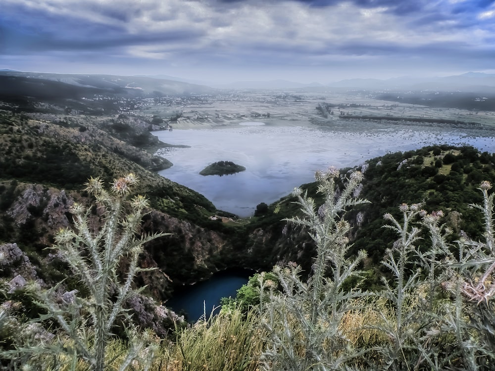 a large body of water surrounded by a lush green hillside