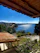 Cozy seaside vacation home with vibrant flowers and a view of the sparkling blue sea at sunset.