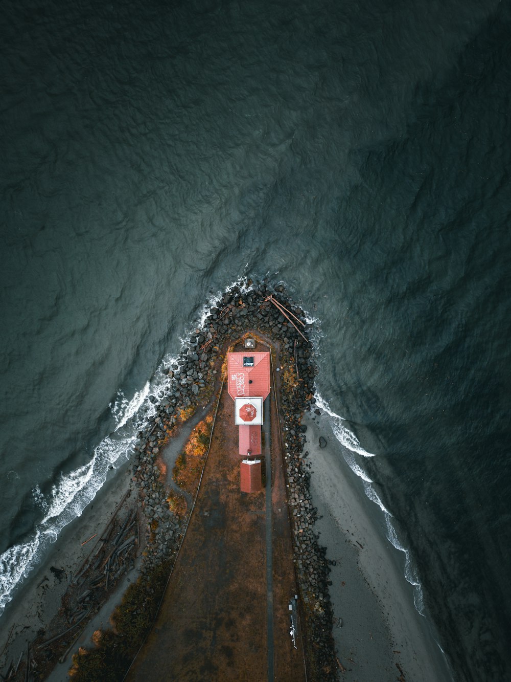 an aerial view of a building on the shore of a body of water