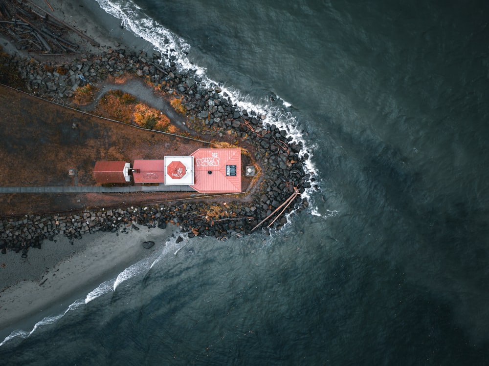 an aerial view of a lighthouse on the shore