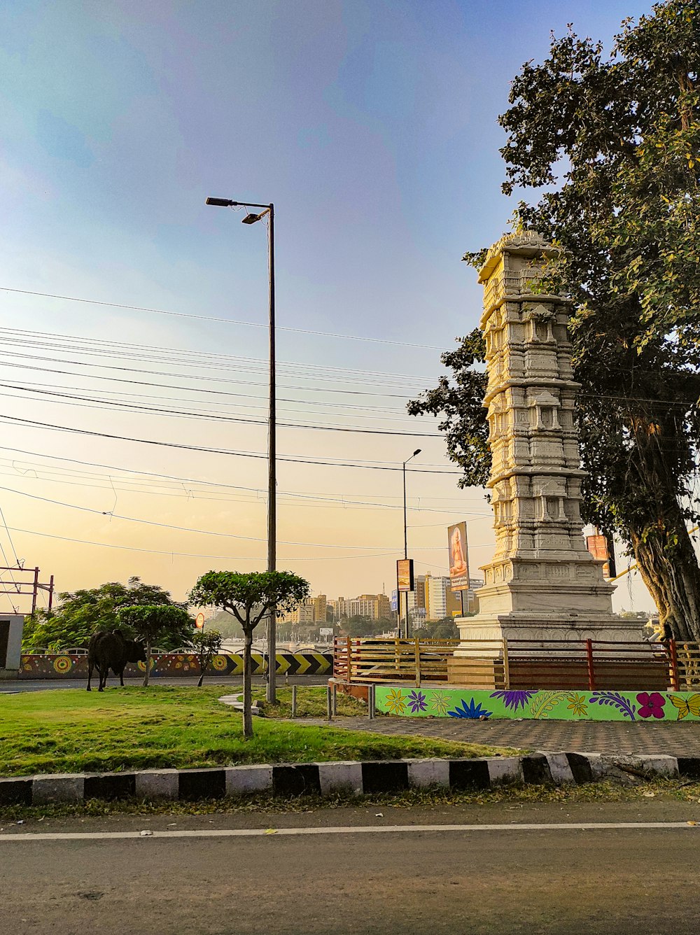 a tall white clock tower sitting on the side of a road