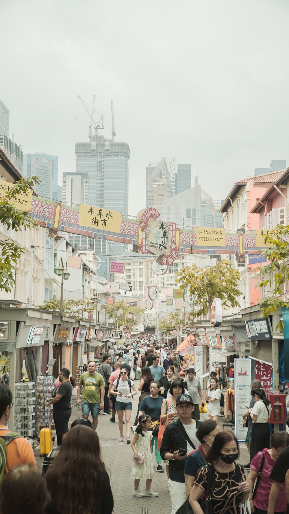 a crowd of people walking down a street next to tall buildings