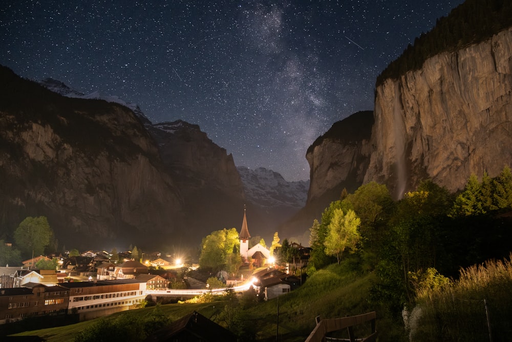 a night time view of a town with mountains in the background
