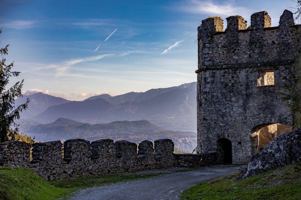 a stone castle with mountains in the background