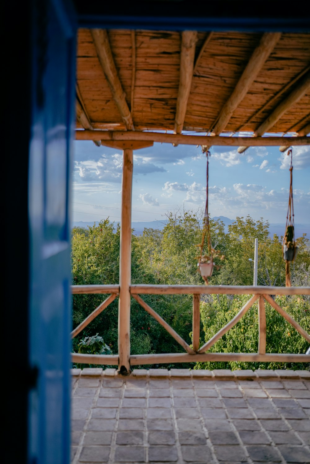a porch with a swing and a view of a forest