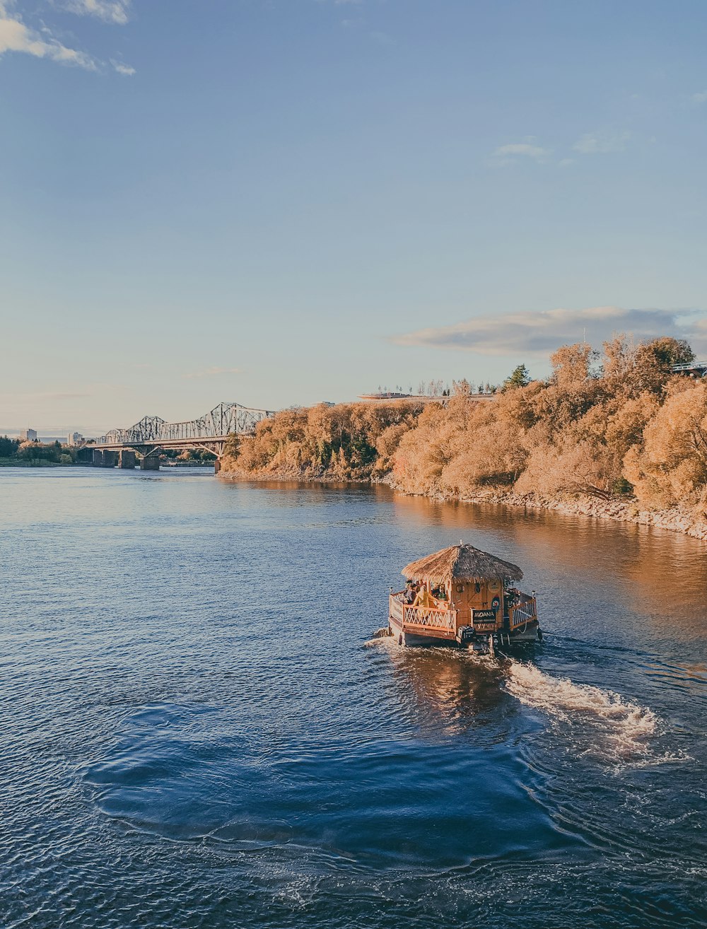 a boat traveling down a river next to a bridge