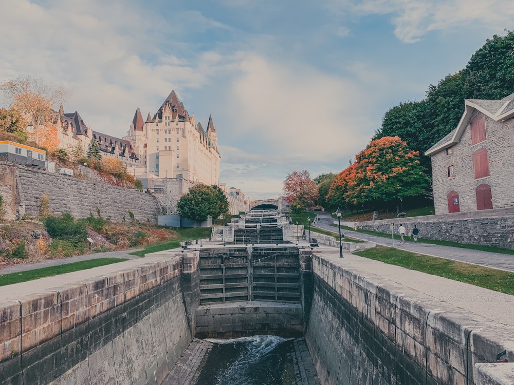 a canal running through a city with a castle in the background