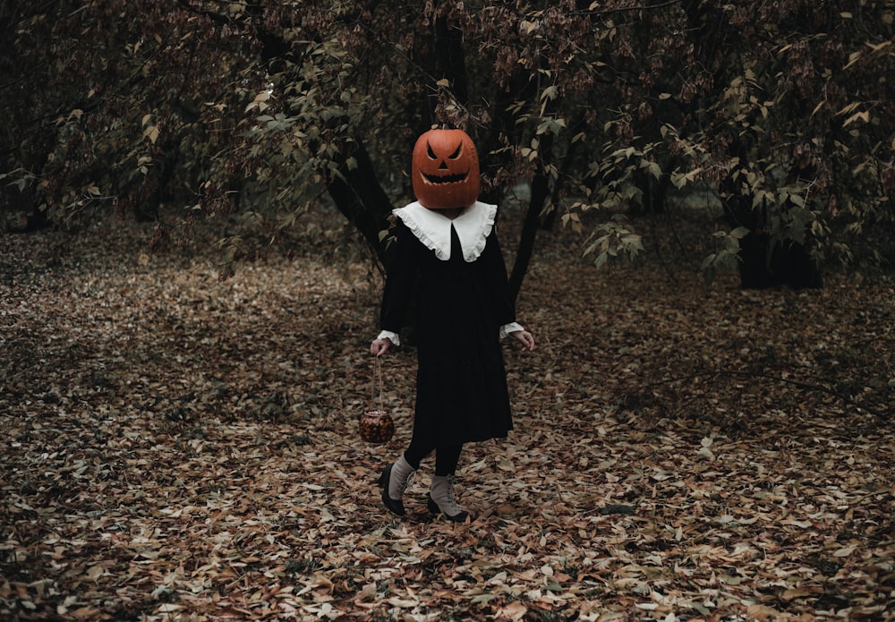 a person in a black dress and a pumpkin hat