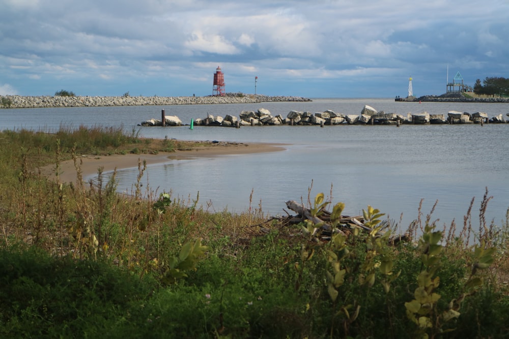 a body of water with a light house in the background