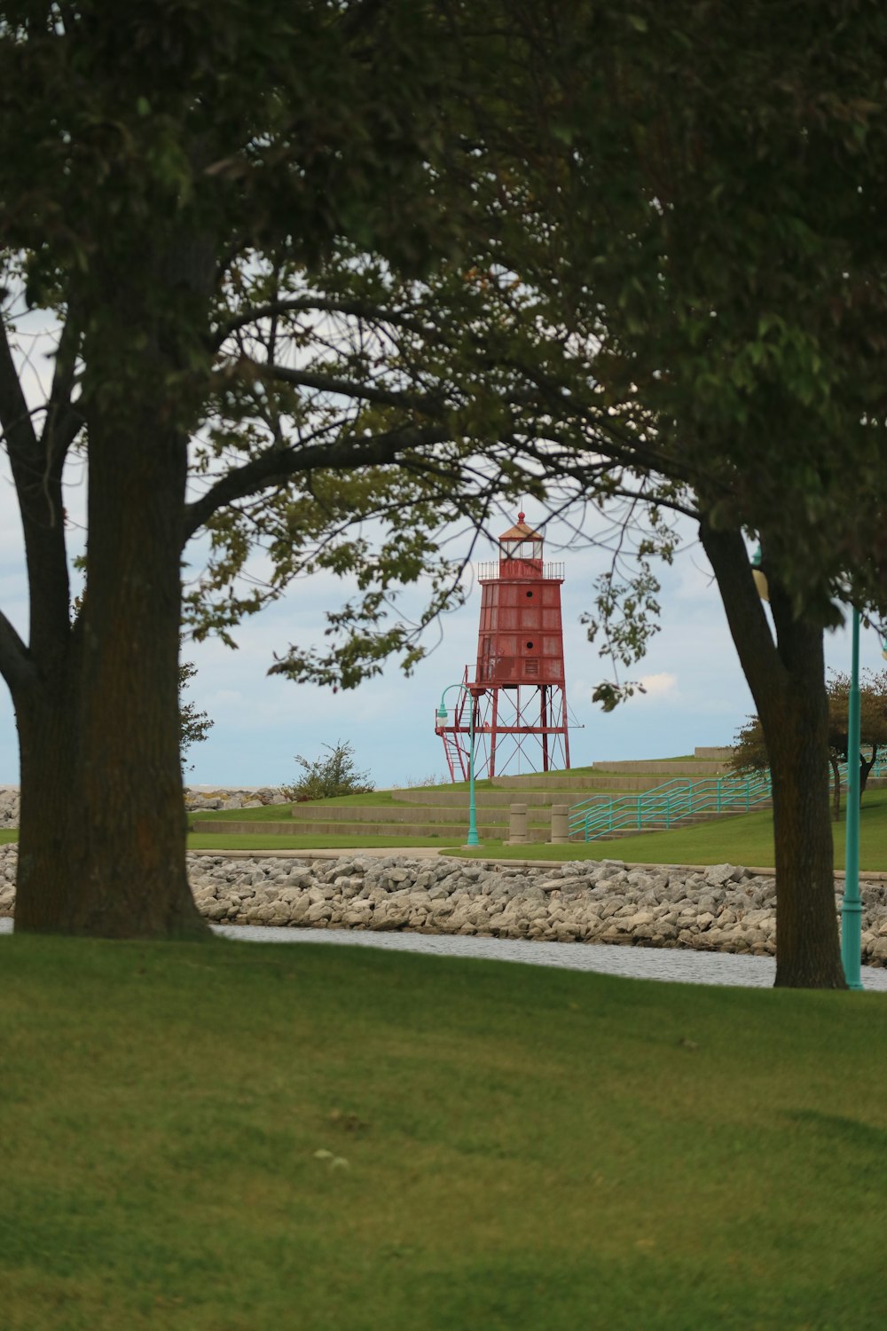 a red tower in the middle of a park