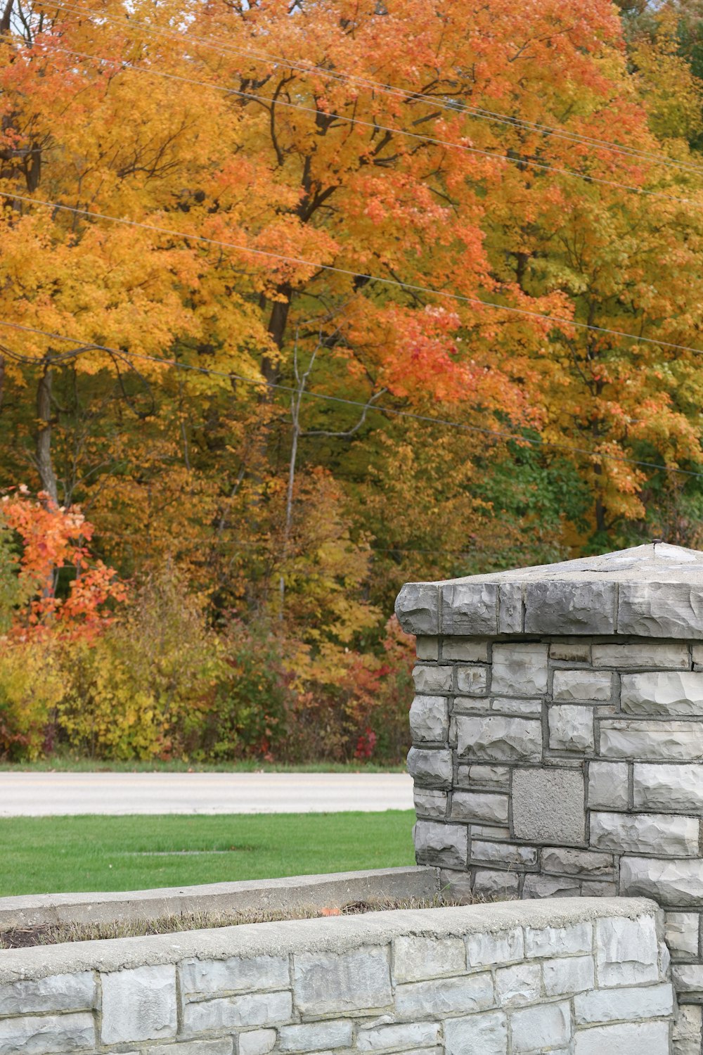 a person sitting on a bench in front of a stone wall