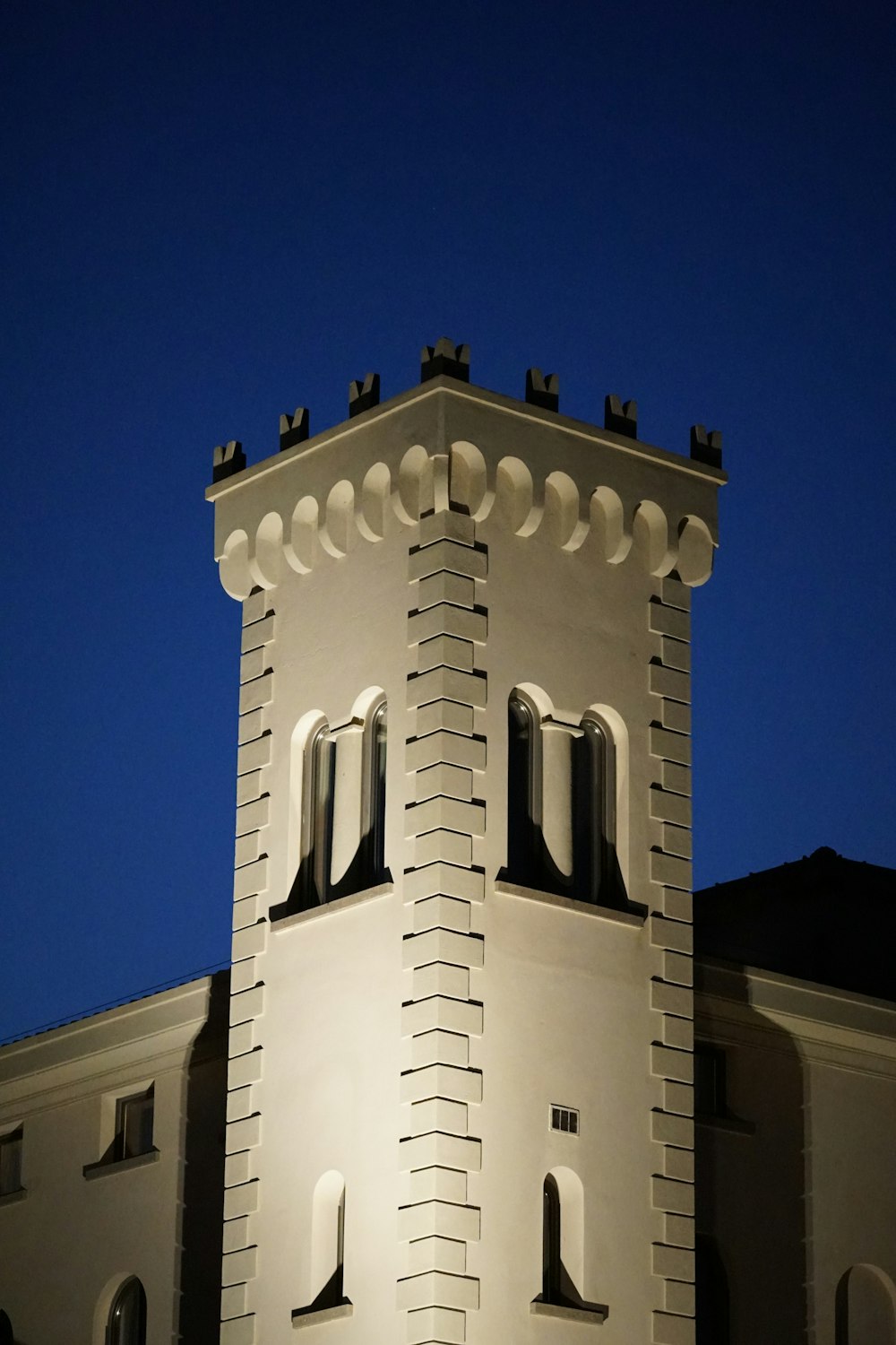 a tall white tower with a clock on it's side