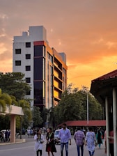 Modern residential building with landscaped gardens at sunset.