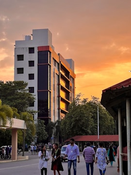 A modern residential building with landscaped gardens at sunset.