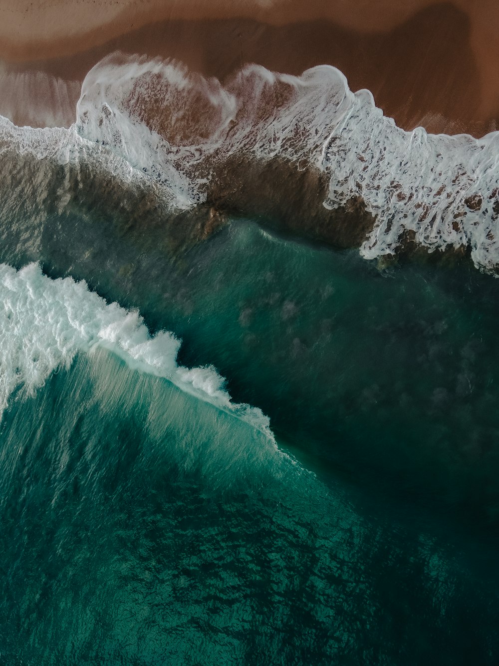 an aerial view of the ocean with waves