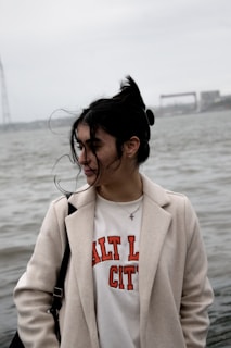 a woman standing in front of a body of water