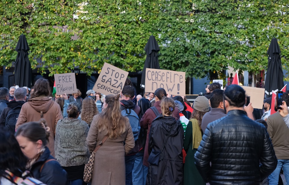 a group of people holding signs in front of a building