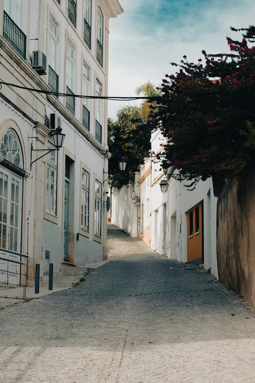 a narrow street with white buildings on both sides