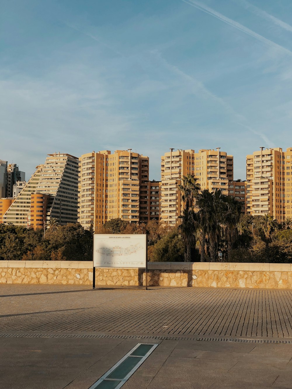 an empty parking lot in front of some tall buildings