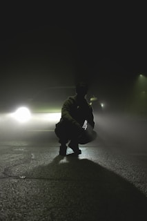 A dramatic scene from a suspenseful movie with a silhouetted figure.